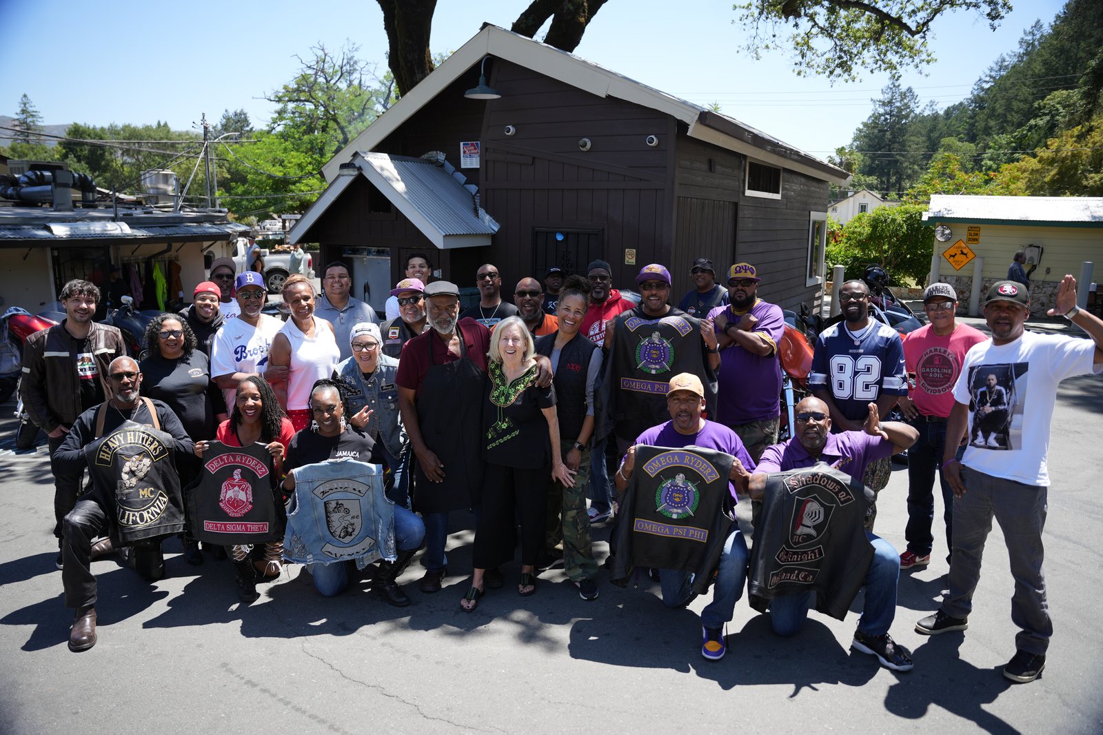 Group photo outside Busters of Calistoga with Omega Ryderz, Delta Ryderz, Heavy Hitters, and Shadows of Knight vests displayed, 2025 Freedom Ride