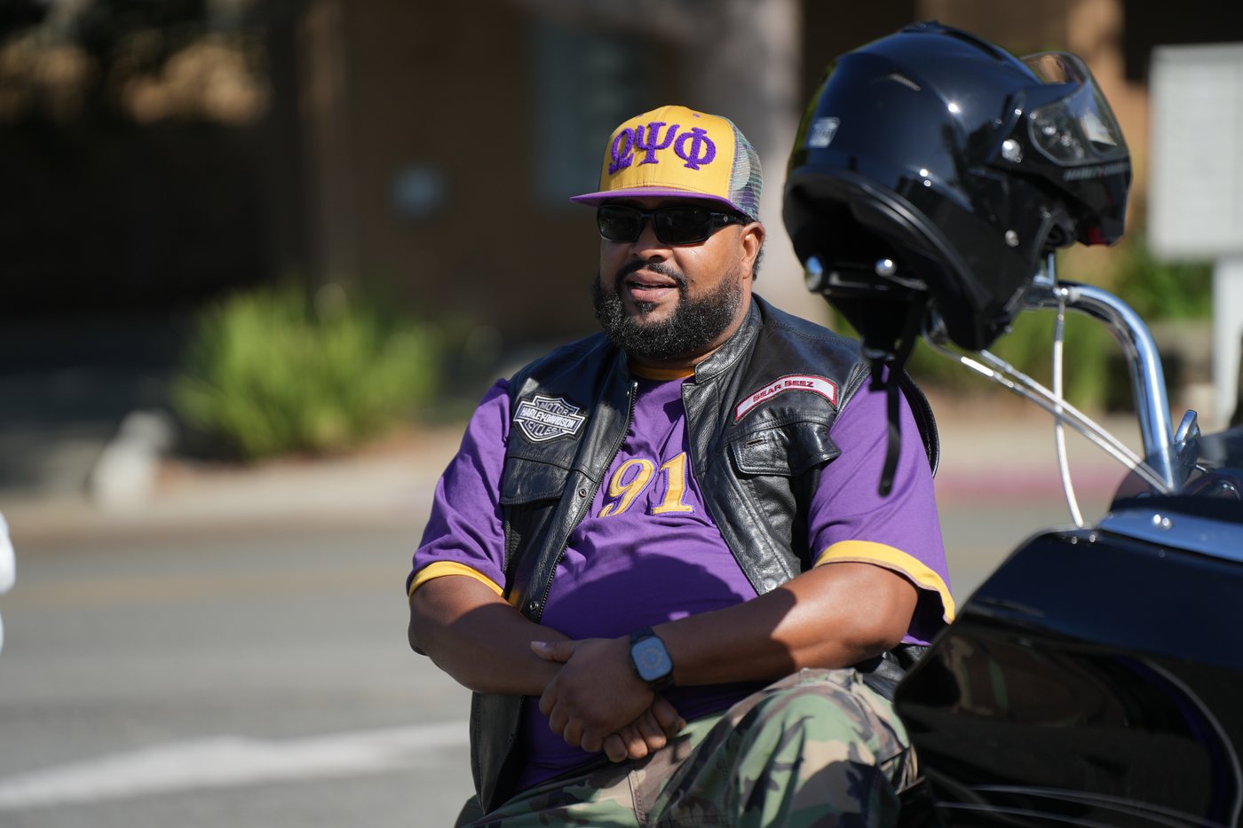 Omega Psi Phi member in purple jersey and Harley vest seated on his bike at staging, 2025 Freedom Ride
